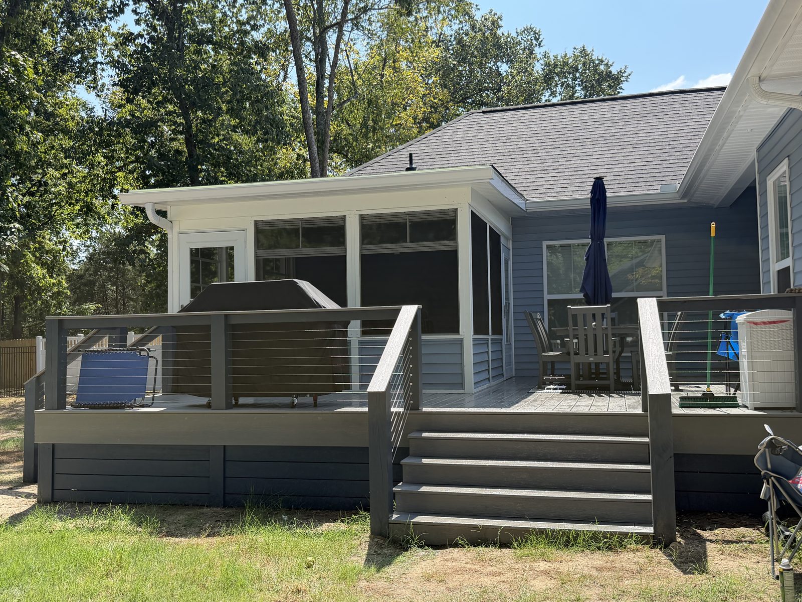 Composite deck and screened porch with cable rail on a light blue house in Mount Juliet