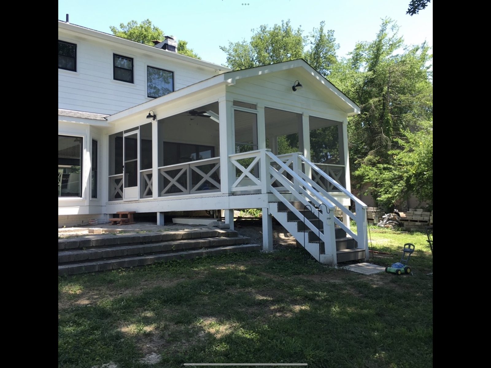 White screened porch with decorative X-pattern railings