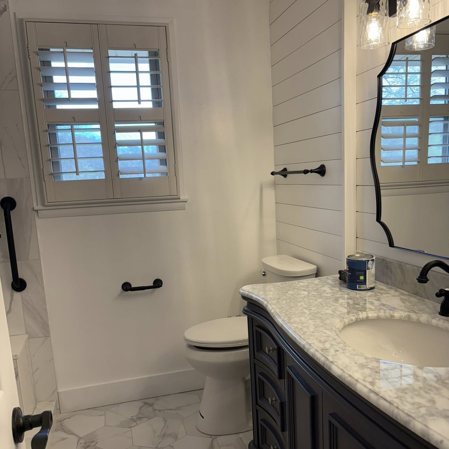Finished bathroom remodel with marble vanity, shiplap walls, and modern fixtures